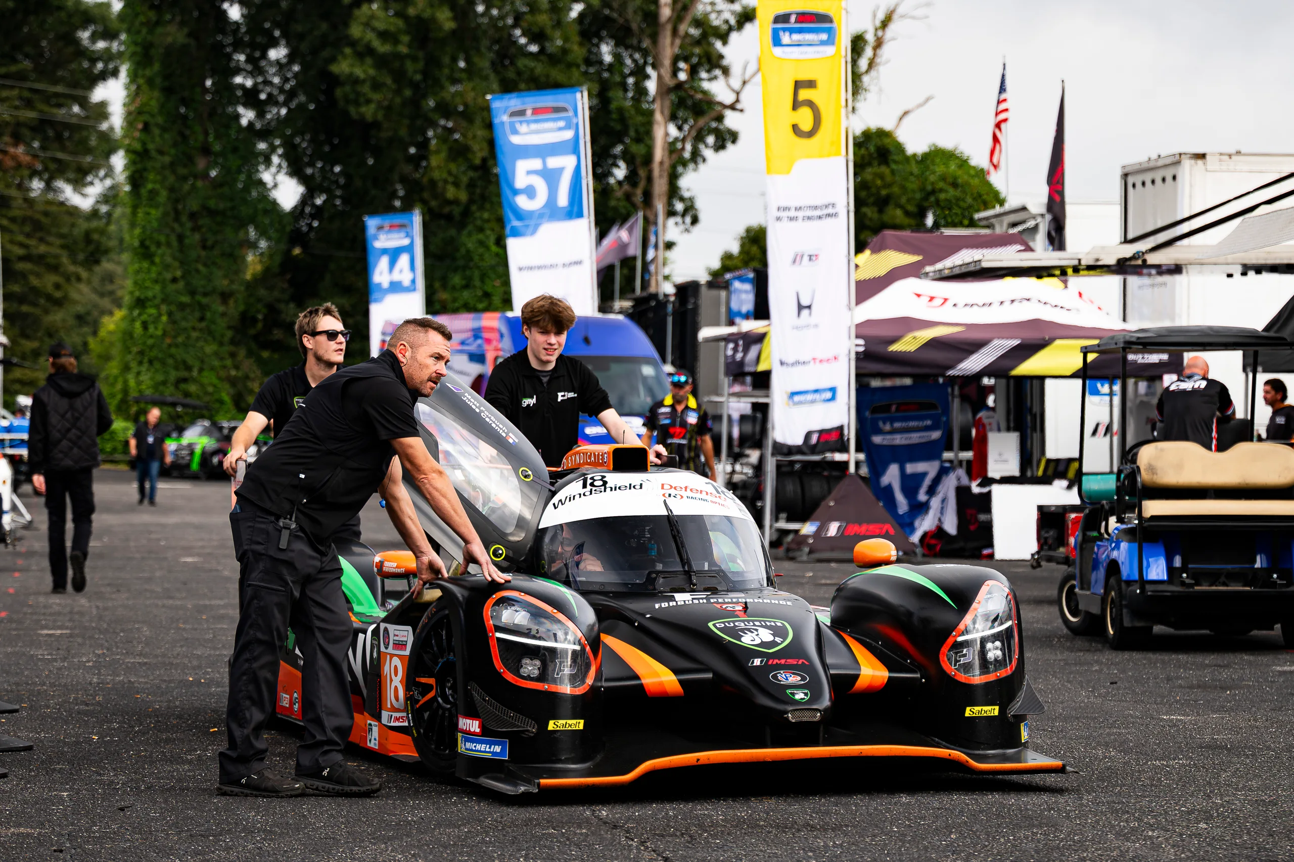 Forbush Performance crew members push the No. 18 Duqueine through the Road Atlanta paddock